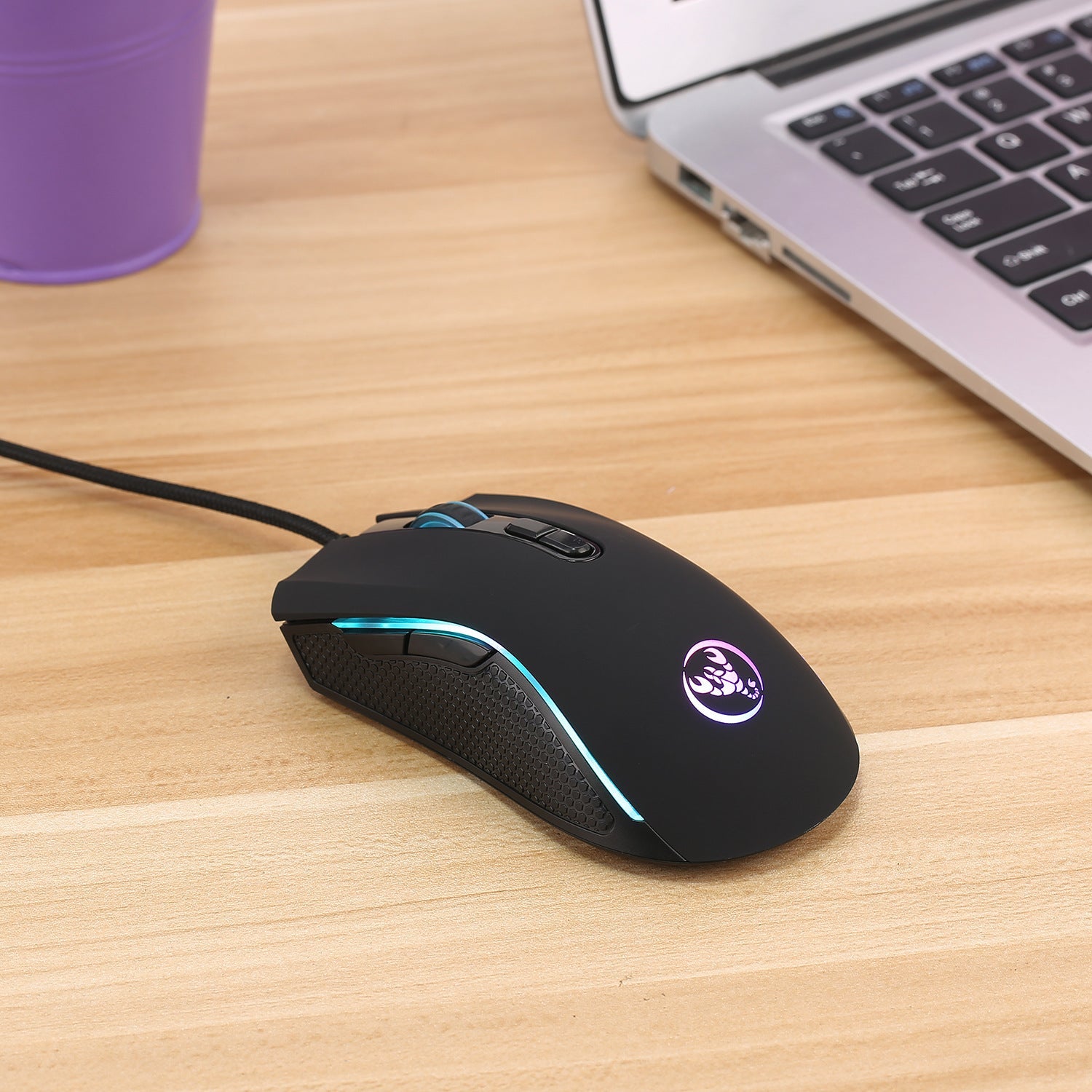 Black RGB wired gaming mouse on a clean desk setup